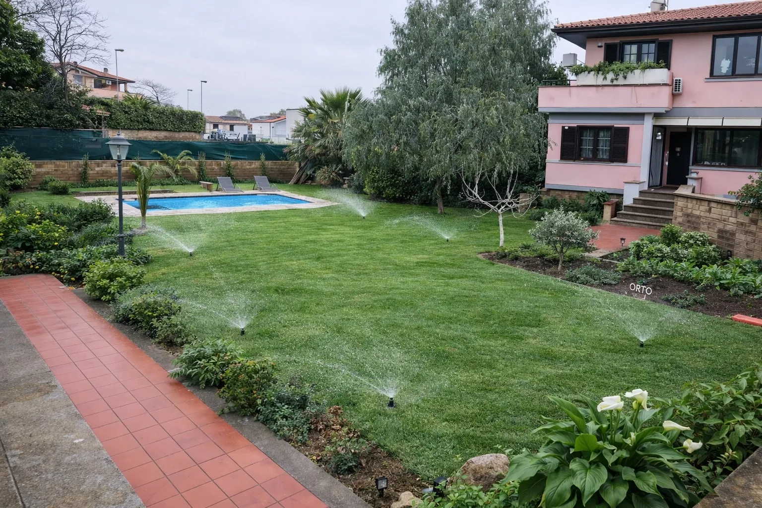 Prato a rotoli appena posato nel giardino di una villa con piscina, bagnato dagli irrigatori a scomparsa